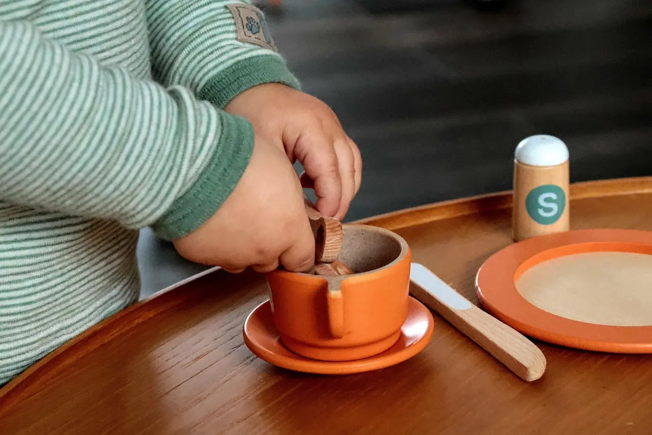 Barns hænder der leger med trælegetøj